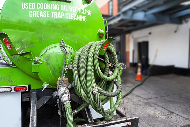 a professional service truck pumping a grease trap in Alto